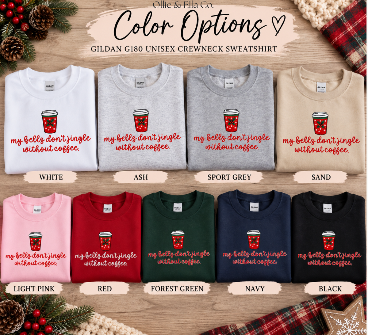 A color options chart for a Gildan G180 unisex crewneck sweatshirt, showing ten folded sweatshirts in different colors (white, ash, sport grey, sand, light pink, red, forest green, navy, black) with a red coffee cup graphic and the slogan 'my bells don't jingle without coffee' on a wood background.